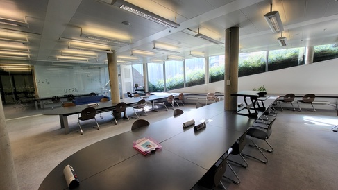 a 'fish-eye' style view of most of the glass room study space showing desk spaces and glass walls